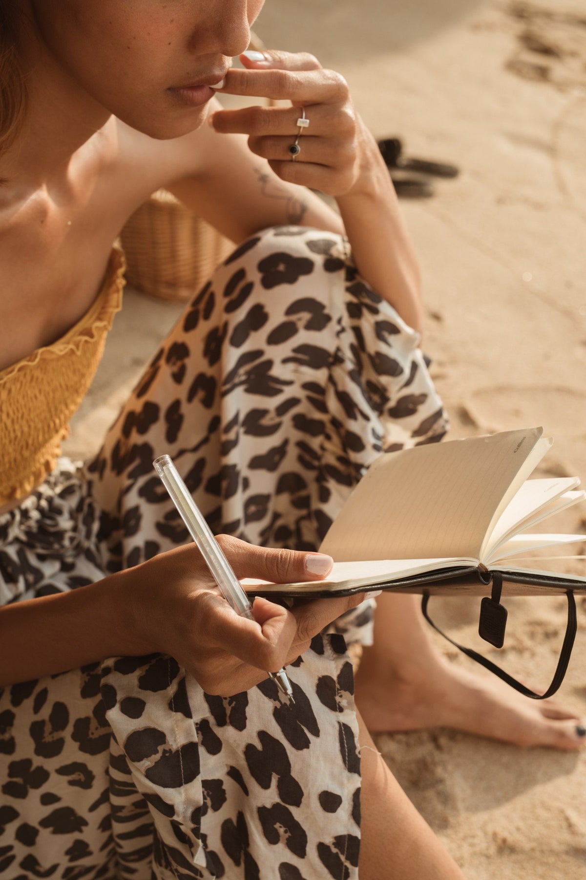 Woman writing in a journal with a Bible study open, in warm natural light